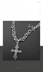 Macro shot of silver titanium steel Cuban chain necklace with Gothic cross pendant detail