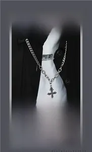 Macro shot of silver cross pendant with gothic details on a heavy curb chain
