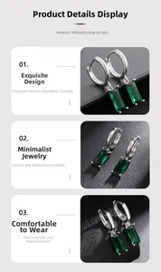 Detail of silver hoop earring featuring a rectangular emerald green gemstone setting