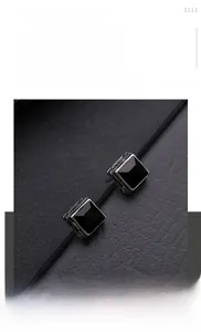 Nahaufnahme von schwarzem Zirkonia-Ohrstecker mit graviertem Edelstahlrahmen im Vintage-Stil