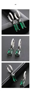 Detailed view of silver hoop earrings featuring rectangle emerald green gemstones