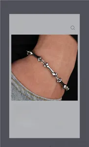 Macro shot of unique bone-shaped chain link bracelet in silver finish on wrist