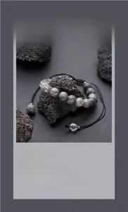Detail of adjustable beaded bracelet with marble texture beads and crystals on volcanic rock
