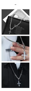 Detailed view of silver gothic cross pendant with embossed pattern and chunky chain link