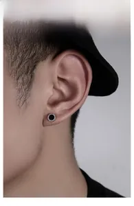 Macro shot of a round stud earring with black center and pavé zircon stones on the ear