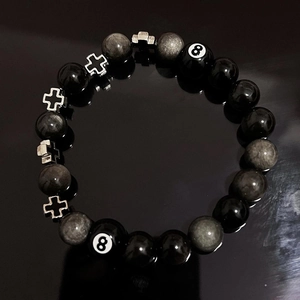 Bracelet en obsidienne avec croix argentées et boule de billard numéro 8 sur fond noir