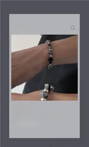 Gros plan du bracelet de perles noires avec pendentif croix centrale de style gothique