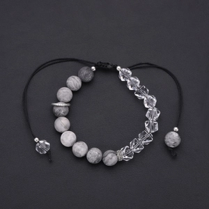 Adjustable gray marble and clear crystal beaded bracelet on black leather background