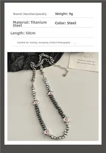Collier en acier titane avec perles cylindriques grises et pendentif œil maléfique rose