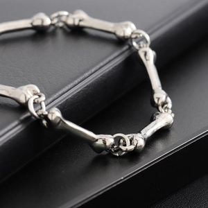 Polished silver bone link bracelet for men and women on black leather background