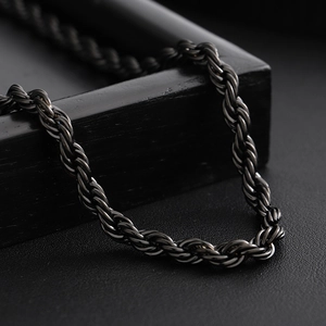 Classic black rope chain necklace with polished finish on a dark textured background