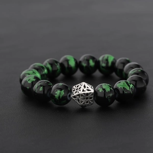 Seraphinite beaded bracelet with engraved silver charm on black leather background