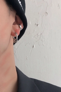 Detail of silver minimalist hoop earring set on ear with small round bead charm