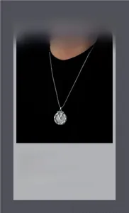 Détail macro du pendentif collier argenté avec chiffres romains et serti de diamants