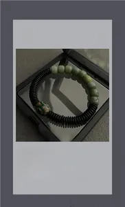 Dettaglio delle perle di giada verde e della perla Dzi in una scatola nera