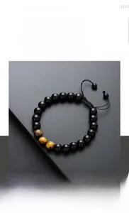 Macro detail of braided tiger eye and obsidian bead bracelet with adjustable cord