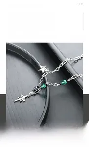 Détail du collier en acier titane avec pendentifs étoile et perles vertes