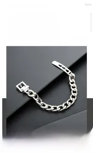 Gros plan d'un bracelet gourmette argenté avec détail de fermoir à boucle métallique