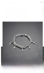 Détail du bracelet gourmette en acier titane argenté avec des pendentifs éclair