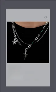 Détail d'un collier double épaisseur argenté avec perles vertes et pendentifs étoiles