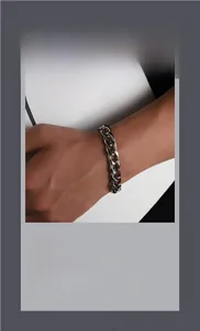 Gros plan d'un bracelet gourmette argenté épais au poignet avec texture minimaliste