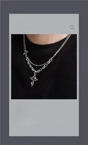 Detail of layered silver chain necklace with two cross pendants in a gothic hip-hop style