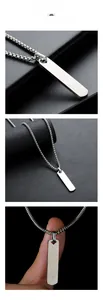 Macro detail of silver rectangular pendant and box chain necklace on black leather