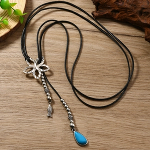 Détail de la fleur vintage et du pendentif goutte bleue sur collier long bohème