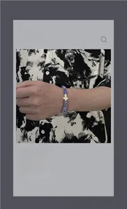 Gros plan d'un bracelet en perles bleues avec pendentif croix dorée au poignet