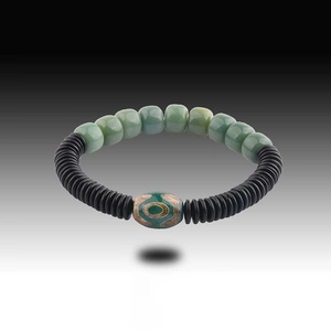 Bracciale etnico con perle Bodhi verdi, distanziatori neri e pietra Dzi centrale decorata