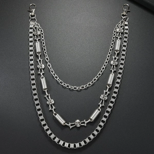 Detailed macro of triple-layered silver wallet chain with skull charms and spring links