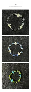 Affichage vertical de trois bracelets à perles avec croix sur papier noir texturé