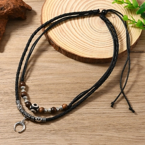 Detail of woven boho necklace with wooden beads and silver crescent moon pendant
