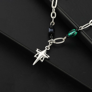 Collier étoile à quatre branches avec perles noires et gemme verte sur fond en cuir