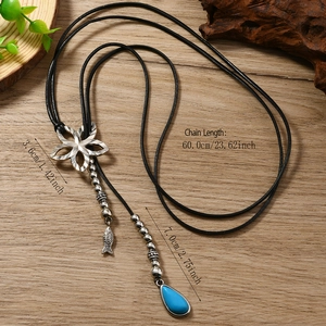 Sautoir fleur vintage avec pendentif goutte bleue sur fond en bois clair