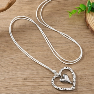 Collier à pendentif cœur argenté avec texture martelée sur corde tressée blanche en bois