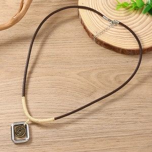 Dettaglio della collana con pendente a moneta antica e incisione di drago vintage