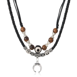 Ethnic retro woven necklace with dark wooden beads and evil eye pendant on white background