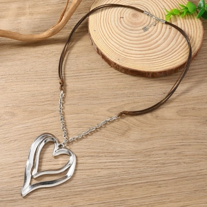 Detail of a large double-layer heart pendant necklace on a rustic wood background