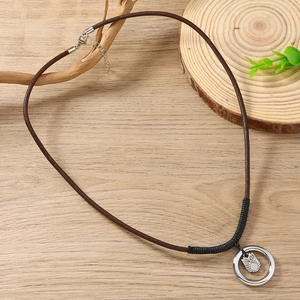 Collier en cuir rétro avec pendentif chouette vintage sur fond en bois naturel