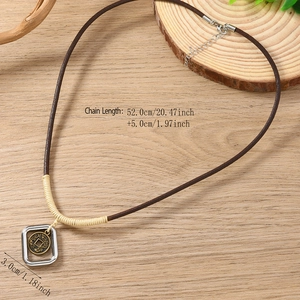 Collana vintage intrecciata con ciondolo a moneta su sfondo in legno naturale