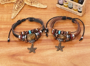 Detail of multi-layer leather bracelets with starfish charms and beads on wood
