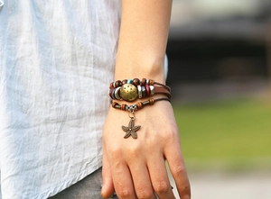 Detail of multilayer leather bracelet with wooden beads and bronze starfish charm