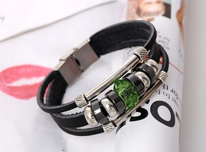 Detailed close-up of multilayer leather bracelet with a green gemstone and steel clasp