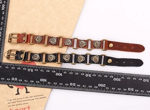 Detail view of adjustable punk leather bracelets with metal buckles on a measuring scale