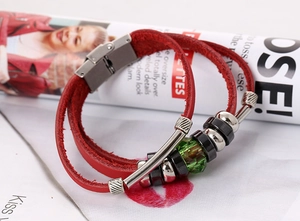 Macro shot of red leather layered bracelet with silver metal tubes and green faceted bead