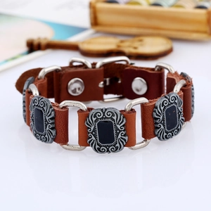 Macro detail of punk style brown leather bracelet with ornate silver scrollwork metal link