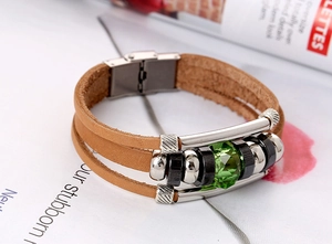 Detailed macro view of vintage multi-layer brown leather bracelet with green crystal stone