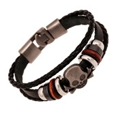 Detail of punk multi-layer leather bracelet featuring skull charms and a matte silver clasp