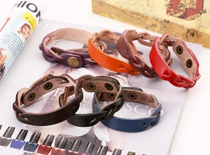 Gros plan de bracelets en cuir tressé multicolores avec fermoir en métal vintage